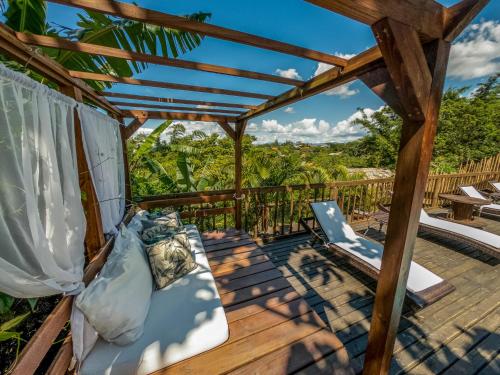 a deck with a bed and a laptop on it at Morada da Praia do Rosa Pousada in Praia do Rosa