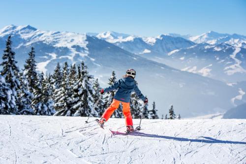 a person is skiing down a snow covered mountain at Appartement Bär in Eben im Pongau