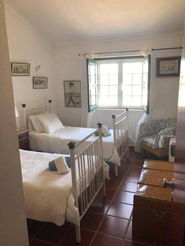 a bedroom with two beds and a window at Monte da Figueira in Amareleja