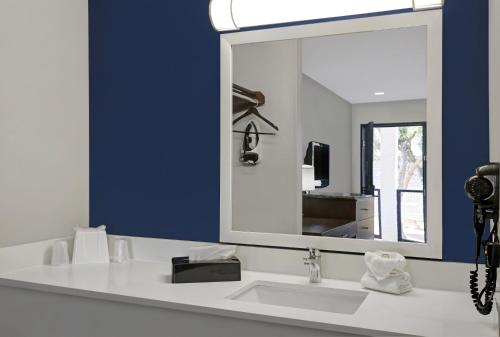 a bathroom with a white sink and a mirror at Atrea Inn Amarillo in Amarillo