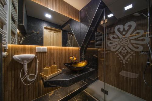 a bathroom with a sink and a shower at Chałpa u Zbójnika in Zakopane