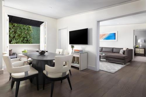 a dining room and living room with a table and chairs at Mosaic Hotel Beverly Hills in Los Angeles