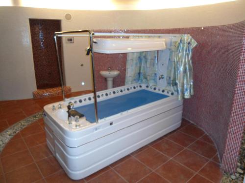 a bath tub in a bathroom with a sink at Pensiunea La Dolce Vita in Băile Herculane