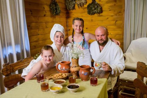 
three people sitting at a table with plates of food at Yuryevskoye Podvorye Boutique Hotel in Velikiy Novgorod
