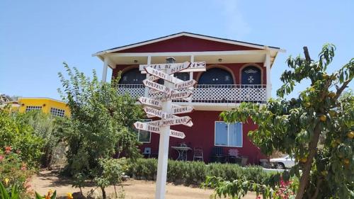 un letrero de la calle frente a una casa roja en Villa De Coral en Valle de Guadalupe