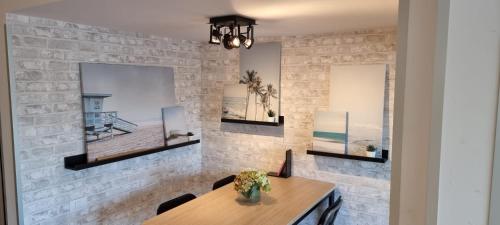 une salle à manger avec une table et un mur en briques dans l'établissement ARGUINEGUIN, two bedrooms bungalow, pool & wifi, à Arguineguín