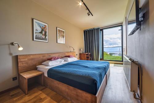 a bedroom with a bed and a large window at Quadrum Hotel in Gudauri