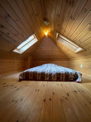 a bedroom with a bed in a wooden room at wietrznie-wichrowe wzgórze in Wólka Ratowiecka