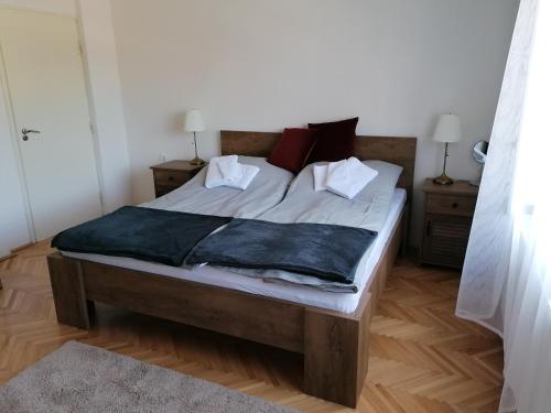 1 dormitorio con 1 cama con sábanas y almohadas blancas en Vendégház a Kerekhegyi Pagonyhoz, en Zebegény
