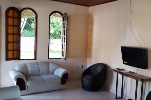 uma sala de estar com um sofá e duas janelas em CASA OURO VERDE - Praia de Mosqueiro em Belém