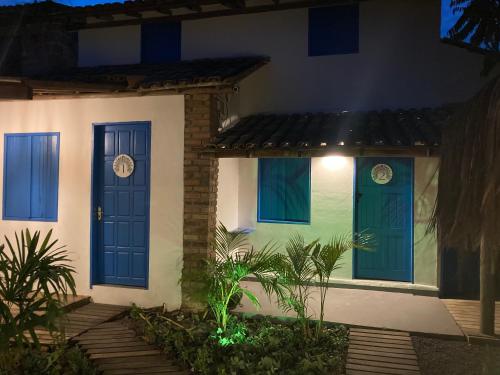 a house with blue doors at night at Pousada Cocar Caraíva in Caraíva