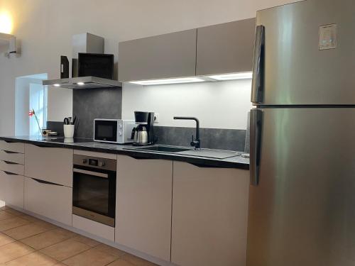 Il comprend une cuisine équipée d'un réfrigérateur et d'appareils en acier inoxydable. dans l'établissement Orangerie de Cardet - Apartment Le Mûrier, à Cardet