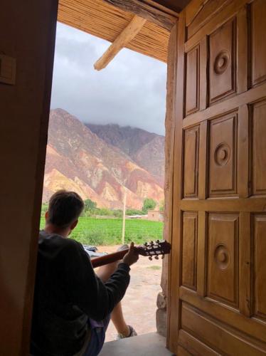 a man looking out of a door at a view at Ruphay: Cabaña equipada con vista a los cerros en el campo in Maimará