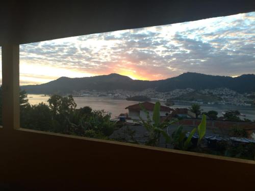 a view of a sunset from a window at Alto do Marinas in Angra dos Reis