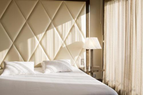 a bedroom with a large bed with white pillows at Le Safari Hotel Restaurant in Carpentras