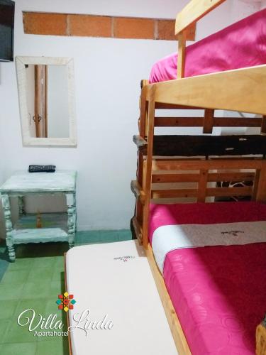 a bedroom with two bunk beds and a table at Villa Linda ApartaHotel in Jericó