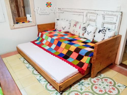 a bedroom with a bed with a colorful quilt at Villa Linda ApartaHotel in Jericó