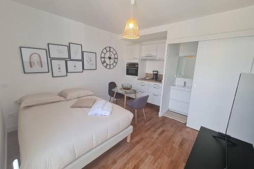 a bedroom with a bed and a table and a kitchen at Le Poulorio 9 - Studio - Proche Gare By Locly in Lorient