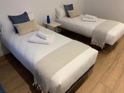 two beds sitting next to each other in a room at OKTHEWAY PERBES HOUSE in A Coruña