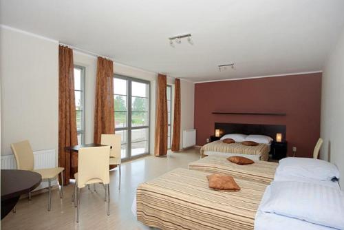 1 dormitorio con 2 camas, mesa y sillas en Eurybia, en Łeba