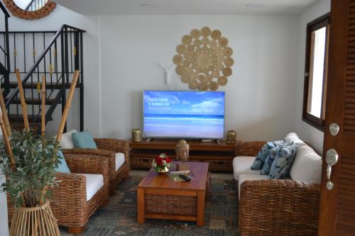 a living room with wicker furniture and a flat screen tv at Condominio Atlantis in Coveñas