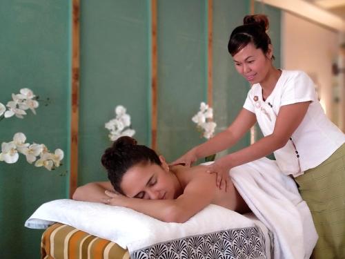 a woman giving a man a massage on a bed at Bazar du Nouveau Siècle in Montréjeau