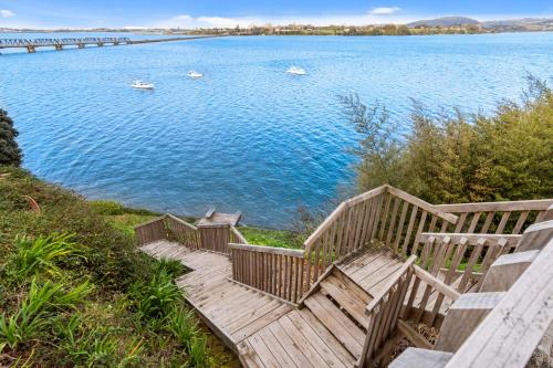 a wooden staircase leading to a large body of water at The Tauranga on the Waterfront in Tauranga