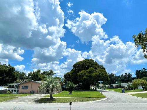 a road in a neighborhood with a cloudy sky at Curly Sunshine Clearwater in Clearwater