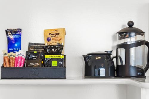 a shelf with a coffee pot and books on it at The Tauranga on the Waterfront in Tauranga