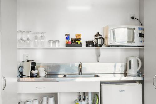 a kitchen with a sink and a microwave at The Tauranga on the Waterfront in Tauranga