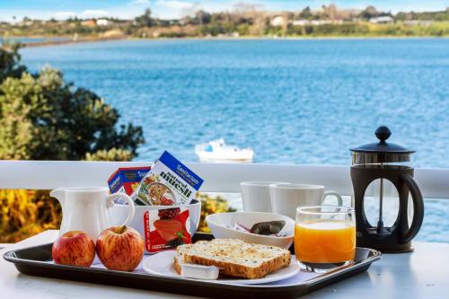 a tray of breakfast food on a table by the water at The Tauranga on the Waterfront in Tauranga
