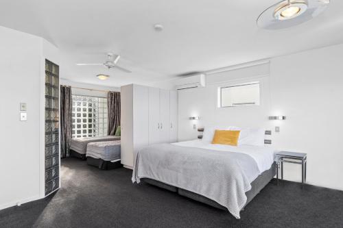 a white bedroom with a bed and a window at The Tauranga on the Waterfront in Tauranga