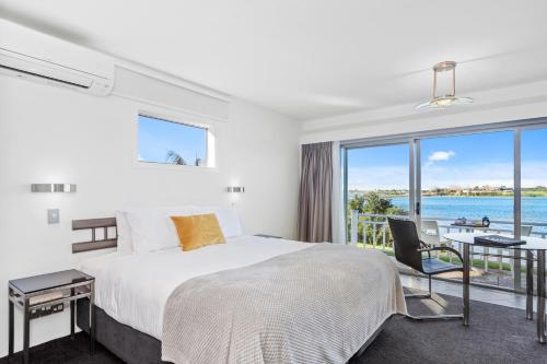 a bedroom with a bed and a view of the ocean at The Tauranga on the Waterfront in Tauranga