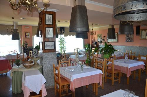 a restaurant with tables and chairs in a room at Bahia de Chapela in Redondela
