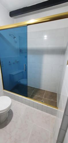 a bathroom with a toilet and a large glass window at Hostal Flores in Quito