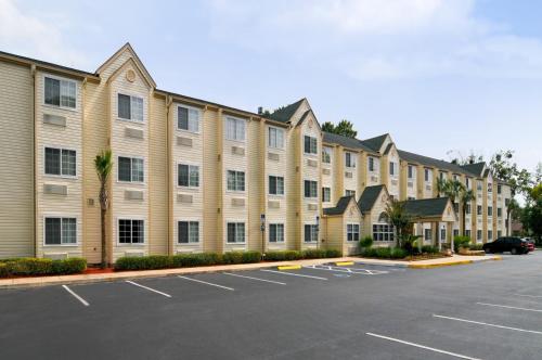 a large building with a parking lot in front of it at Hometown Inn & Suites Jacksonville Butler Blvd./Southpoint in Jacksonville