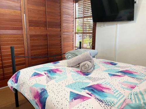 uma cama com um edredão e uma toalha em Bongaree Ocean Villa em Bongaree