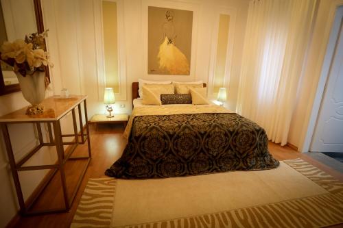 a bedroom with a bed and two tables with lamps at Vila Essel in Korçë