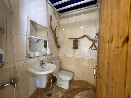 a bathroom with a toilet and a sink at Happiness Factory in Huxi