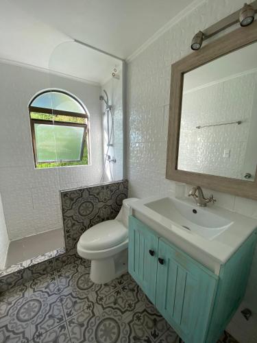 a bathroom with a toilet and a sink and a mirror at Puerto Velero/ Primera Linea in Puerto Velero