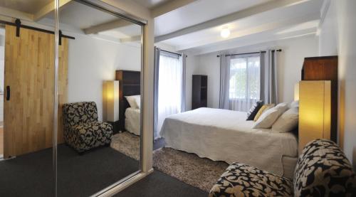 a bedroom with a bed and a mirror at Bribie Beach Bungalow in Bongaree