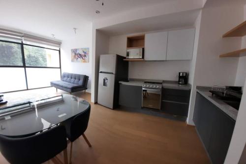 a small kitchen with a table and a refrigerator at Increible Loft frente al WTC, Napoles in Mexico City