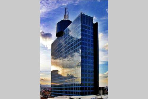 a tall glass building with a reflection of the sky at Increible Loft frente al WTC, Napoles in Mexico City