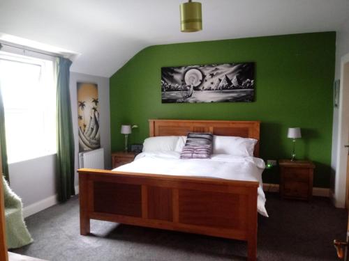 Un dormitorio con una pared verde y una cama grande en Country House and Spa, en Coleraine