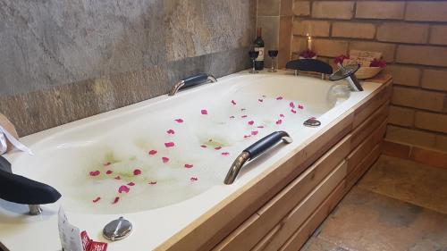 a bath tub filled with red hearts in a bathroom at Casona Real Santa Barbara in Ráquira