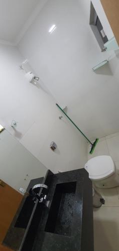 a bathroom with a toilet and a light on the ceiling at Casa Temporada Aruanã Rio Araguaia in Aruanã
