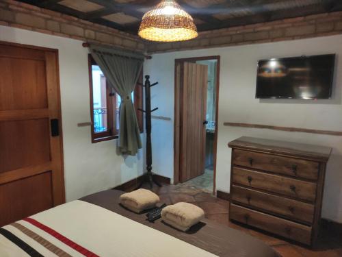 a bedroom with a bed and a dresser and a window at Casona Real Santa Barbara in Ráquira