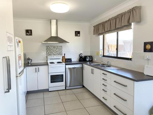 a kitchen with white appliances and a window at Cloud 8 on Welsby in Bongaree