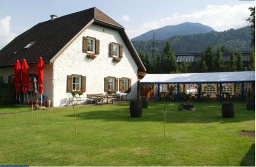 a large white house with a tent in a yard at Seehaus Kärnten in Saager