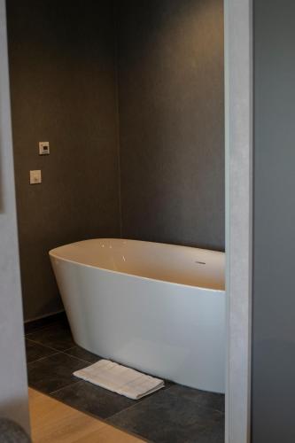 a white bath tub sitting in a bathroom at mk hotel tirana in Tirana